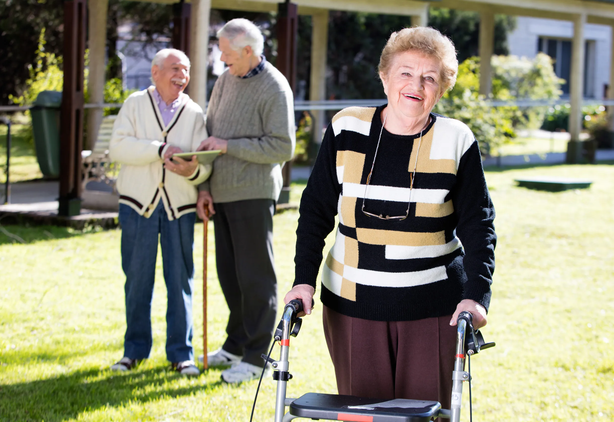 Happy retired woman with walker in a rehab clinic outdoor